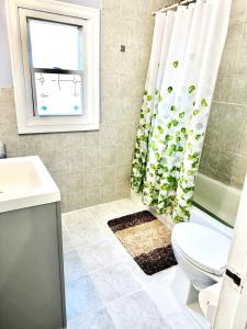 a bathroom with a toilet and a shower curtain at 3 bedrooms 1 bath APT, 10 min to Manhattan! in Long Island City
