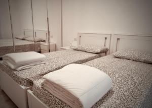 a white room with two beds with mirrors at Maison Du Pic - Rho Fiera in Pero