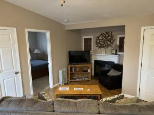 a living room with a couch and a fireplace at Tree House , Bagnell Dam area in Lake Ozark