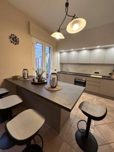 a kitchen with a large island with two stools at Dimora Lucchese in Lucca