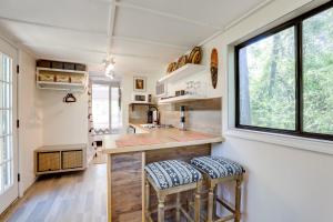 una cocina con dos taburetes en un mostrador en una casa pequeña en Georgia Tiny Home on Farm Retreat Hike On-Site! en Lithonia