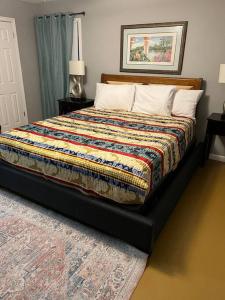 a bedroom with a bed with a colorful blanket on it at Chic Rancher 7BR Compound Near Graceland & Airport in Memphis