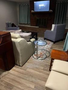 uma sala de estar com sofás e uma televisão de ecrã plano em Chic Rancher 7BR Compound Near Graceland & Airport em Memphis