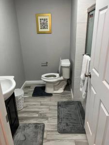 a white bathroom with a toilet and a sink at Chic Rancher 7BR Compound Near Graceland & Airport in Memphis