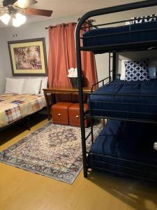 メンフィスにあるChic Rancher 7BR Compound Near Graceland & Airportの二段ベッド2台、デスクが備わる客室です。