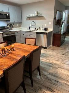 uma cozinha com uma mesa de madeira e um piso de madeira em Chic Rancher 7BR Compound Near Graceland & Airport em Memphis