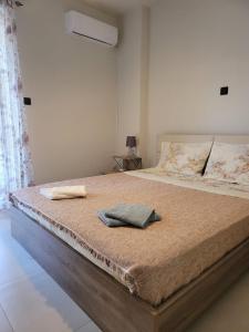 a bedroom with a bed with two towels on it at Stephie's apartment by the sea in Rafina