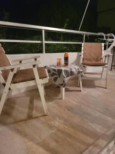 Duas cadeiras e uma mesa sentadas num deque em Stephie's apartment by the sea em Rafina