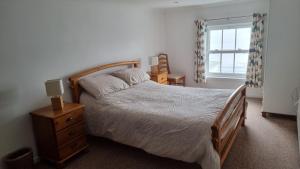 Un dormitorio con una cama grande y una ventana en Little Harbour Self Catering en Stanley