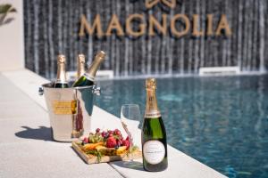 2 bottiglie di champagne e un cesto di frutta accanto alla piscina di Magnolia Luxury Villa a Vieira de Leiria