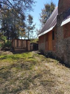 an old brick building with a wooden fence next to it at RedStone Cabin in El Oro de Hidalgo