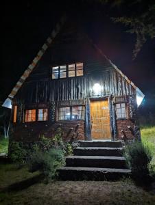 a wooden house with stairs in front of it at night at RedStone Cabin in El Oro de Hidalgo