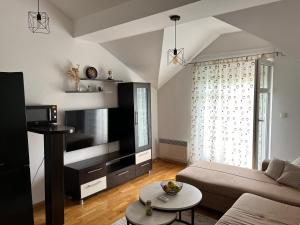 a living room with a couch and a tv at Apartman Mak in Mostar