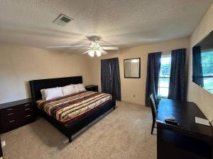 Un dormitorio con una cama y un ventilador de techo. en Peaceful & Elegant Sleeps 16 with Pool Near Mall, en Memphis