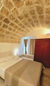 um quarto com uma cama e um tecto de pedra em Palazzo Scianni Dimora della Petraia em Monopoli