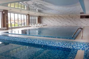 a large swimming pool with blue and white tiles at Sea View & SPA 10d10 in Dziwnów