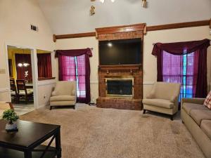 Una sala de estar con chimenea y TV de pantalla plana. en Peaceful & Elegant Sleeps 16 with Pool Near Mall, en Memphis