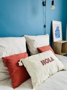 een bed met kussens en een blauwe muur bij Le Cabieu in Ouistreham
