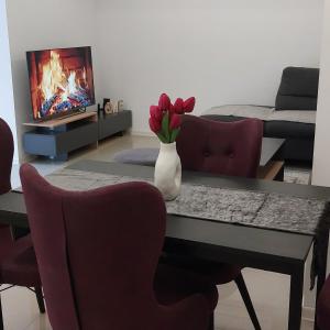 a living room with a table with a vase of flowers at KIKI apartman in Vračar (historical)