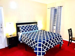 a bedroom with a bed with a blue and white comforter at 3 bedrooms 1 bath APT, 10 min to Manhattan! in Long Island City