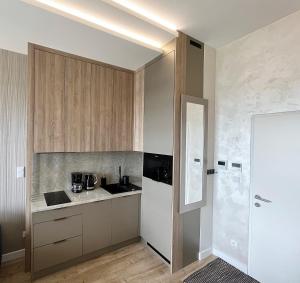 a kitchen with wooden cabinets and a counter top at Shellter Premium Przy Wydmie in Rogowo