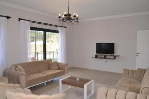 a living room with two couches and a tv at HYVillaS HÜMA in Muğla
