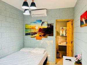 a bedroom with a bed and a painting on the wall at Hostal Camila’s in Tamanique