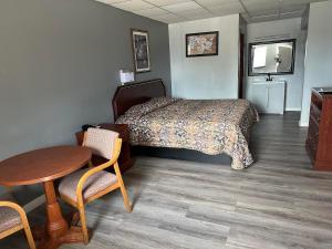 een hotelkamer met een bed en een tafel en stoelen bij Budget Inn-Gadsden in Gadsden