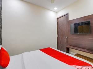 OYO HOTEL KING View في أحمد آباد: غرفة نوم مع سرير وتلفزيون على الحائط