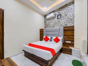ein Schlafzimmer mit einem Bett mit roten Kissen in der Unterkunft OYO HOTEL KING View in Ahmedabad