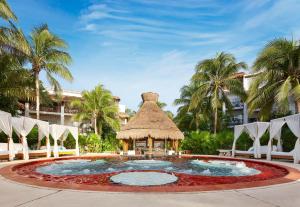Una gran piscina con cenador y palmeras. en Desire Pearl Riviera Maya Resort All Inclusive - Couples Only, en Puerto Morelos