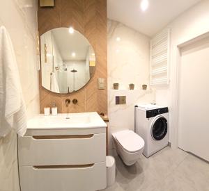 a bathroom with a toilet sink and a washing machine at Apartament Cudny Widok z Sauną - KRAS RESORT in Szklarska Poręba