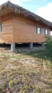 drewniany dom z dachem krytym strzechą w obiekcie Villa Tropicale Fy w mieście Mahajanga