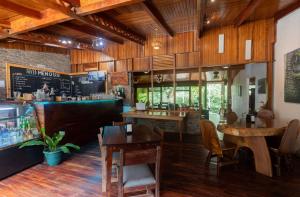 a restaurant with wooden floors and tables and a bar at El Bosque Trails & Eco-Lodge in Monteverde Costa Rica