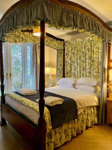 a bedroom with a canopy bed and a window at Wall Eden farm House in Cote