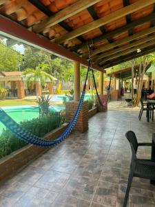 une terrasse couverte avec un hamac et une piscine dans l'établissement HOTEL VILLAS MARIAS, à Puerto Arista