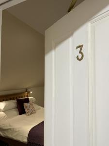 a bedroom with a bed with a number on the wall at Grainbank Mews in Kirkwall