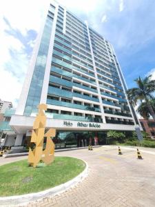 Un gran edificio con una estatua delante. en Alugueasy - Hotel Athos Bulcão, en Brasilia