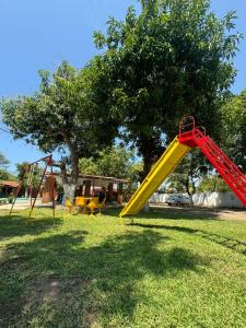 une aire de jeux avec toboggan jaune dans un parc dans l'établissement HOTEL VILLAS MARIAS, à Puerto Arista
