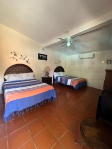 - une chambre avec 2 lits et un ventilateur de plafond dans l'établissement HOTEL VILLAS MARIAS, à Puerto Arista