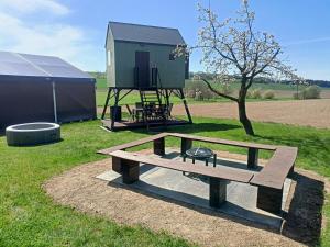 a picnic table and a play house in a field at Posed Kubík in Žďár nad Sázavou
