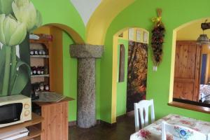 Agroturystyka Leszczynki في ليشنا: غرفة بجدران خضراء وطاولة مع ميكروويف