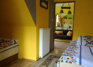 a yellow room with two beds and a mirror at Agroturystyka Leszczynki in Leśna