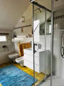 a bathroom with a toilet and a glass shower at Exklusives Haus mit Garten in Hannover