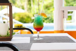 a drink with an orange slice in a glass on a table at Vedanta Resort Barbados in Bridgetown