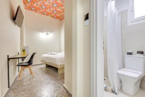 a bathroom with a toilet and a bedroom with a bed at 7ATHENS in Athens