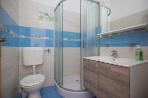 e bagno con servizi igienici, lavandino e doccia. di Apartments Gudelj a Podgora
