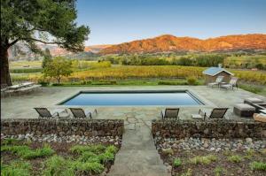 a swimming pool with chairs and a house and mountains at Exclusive Wine Country Estate - The Haven in Healdsburg