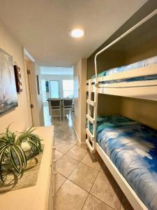 加爾維斯敦的住宿－Seascape 1221 Condo，一间卧室设有两张双层床和一张桌子