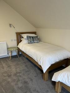 a bedroom with two beds and a night stand at Grainbank Mews in Kirkwall